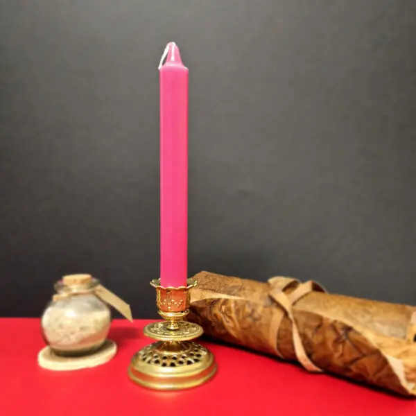 Bougie rose foncé utilisée pour méditation et réconciliation, placée sur une table calme