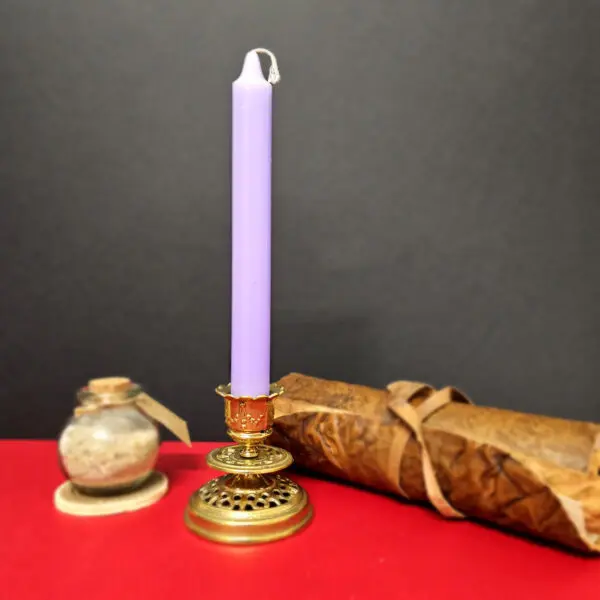 Bougie parme allumée utilisée dans un rituel de guérison spirituelle, amplifiant la purification et la protection