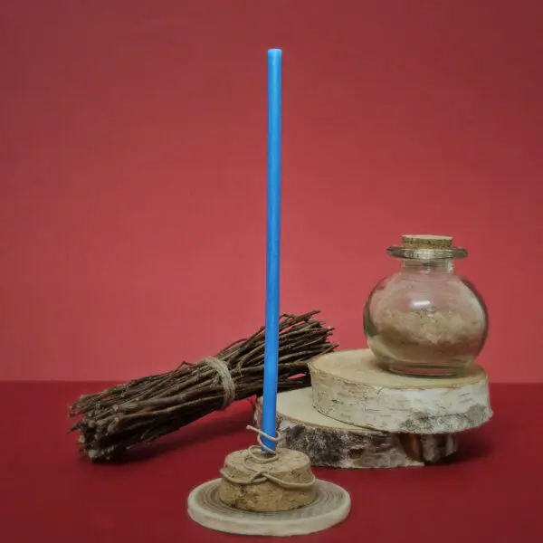 Mini bougie de rituel en cire d’abeille bleu roi allumée, utilisée pour accroître le succès et la protection dans un contexte professionnel