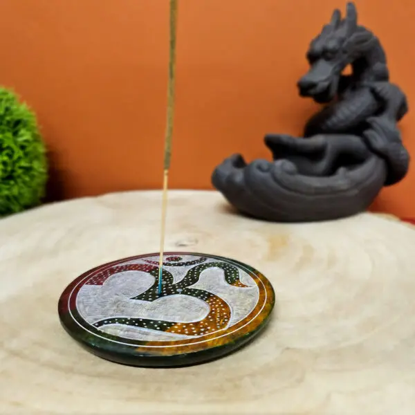 Porte-encens en pierre saponite de 10 cm de diamètre avec le symbole OM gravé. Conçu pour tenir des bâtonnets d'encens, ce support élégant et spirituel offre une base stable et esthétique pour vos rituels de méditation et de purification.