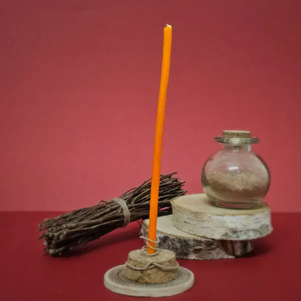 Gros plan d'une mini bougie de rituel orange prête à être allumée, symbolisant la chance et l'augmentation de l'énergie personnelle
