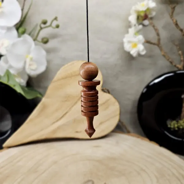 Pendule Osiris en bois naturel, idéal pour la radiesthésie, l'harmonisation énergétique et les pratiques spirituelles. Design élégant et léger pour une utilisation précise.