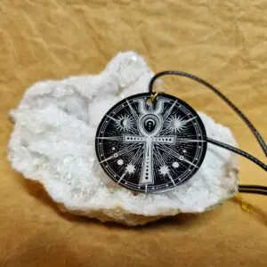 La médaille L’Ankh de Lumière posée sur un cristal blanc montre un ankh entouré d’astres et de lignes lumineuses.