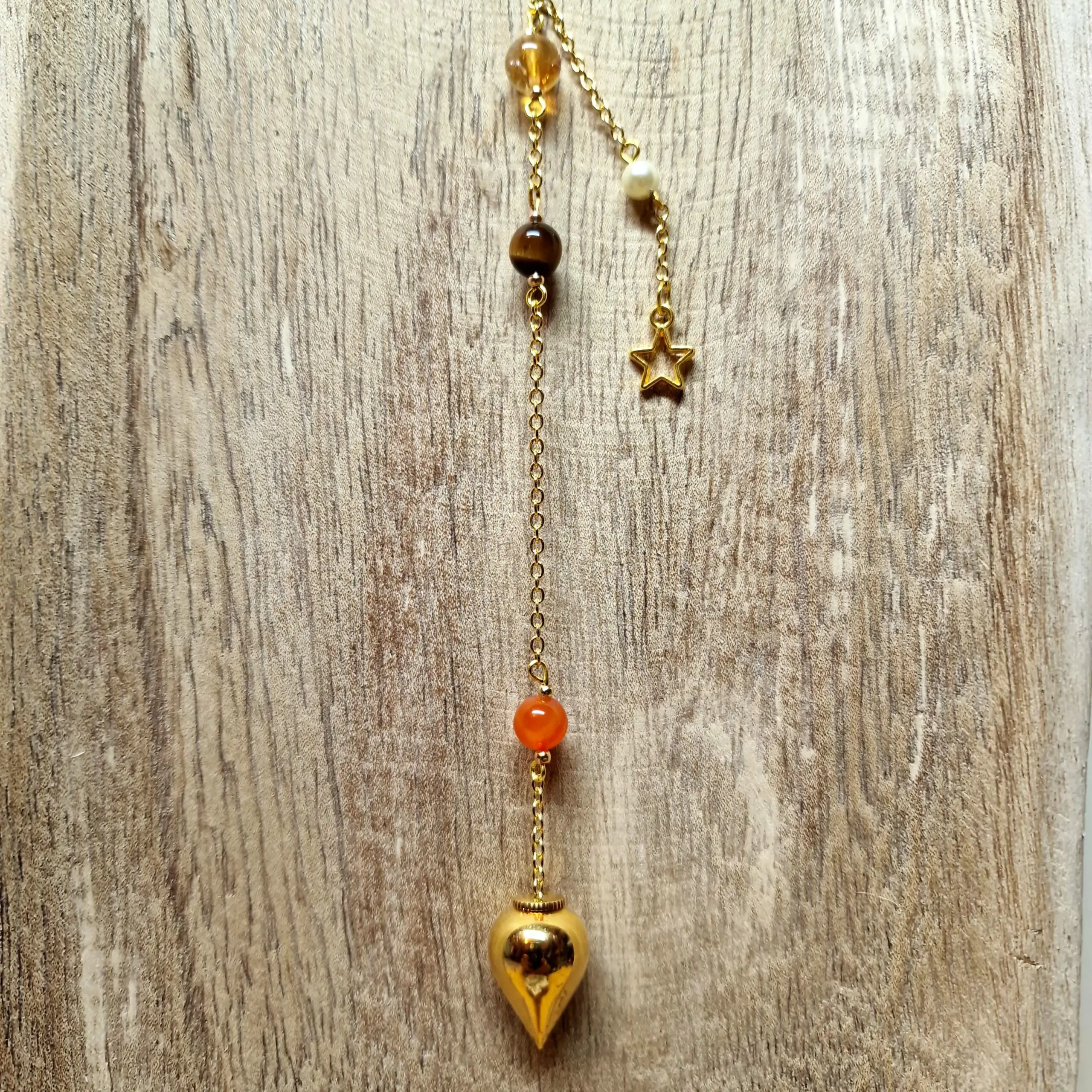 Image du Pendule Chemin de Vie 1 composé de Cornaline, d’Œil de Tigre et de Citrine, créé pour soutenir le courage, la clarté d’esprit et la réussite.