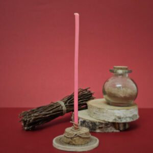 Gros plan d'une mini bougie de rituel rose prête à être utilisée pour des rituels de tendresse et d'affection, favorisant les liens stables et durables