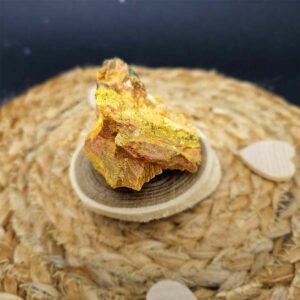 Photo d'une pierre Orpiment aux reflets dorés, utilisée pour stimuler les organes et renforcer le système immunitaire et nerveux.