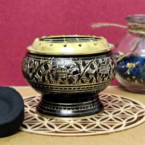 Brûle-encens noir et doré avec incrustations, conçu pour diffuser des encens en grains et résines. Utilisé avec du charbon, il chauffe pendant les rituels spirituels et les cérémonies.