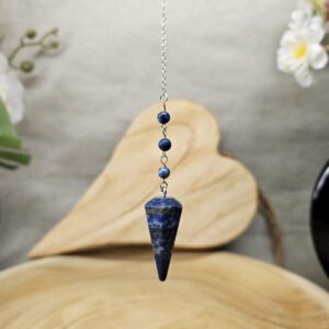 Pendule en lapis lazuli naturel, utilisé pour la radiesthésie et l’éveil spirituel, avec une chaîne en métal argenté, favorisant intuition et sagesse intérieure.