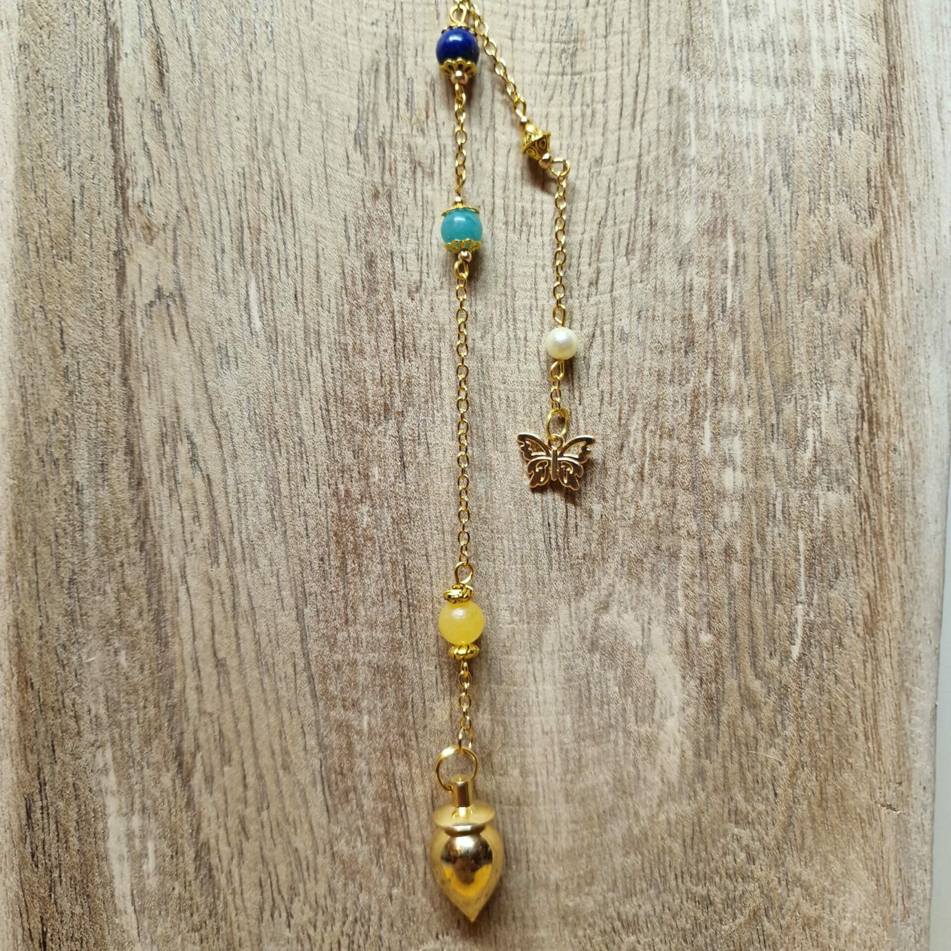 Image du Pendule Chemin de Vie 3 composé de Calcite orange, d’Amazonite et de Lapis-Lazuli pour favoriser la créativité, l’expression et la sagesse intuitive.