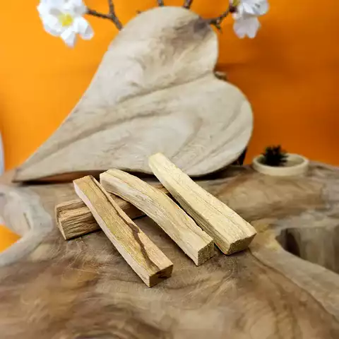 Bâtonnets de palo santo naturel posés sur un support en bois pour rituel de purification et méditation