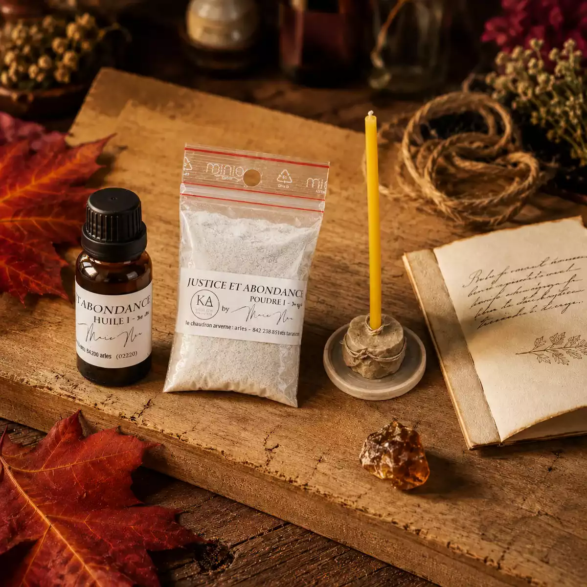 Kit Justice et Abondance avec flacon d’huile, sachet de poudre blanche, mini-bougie miel, feuilles d’érable rouges et livret sur bois ancien.